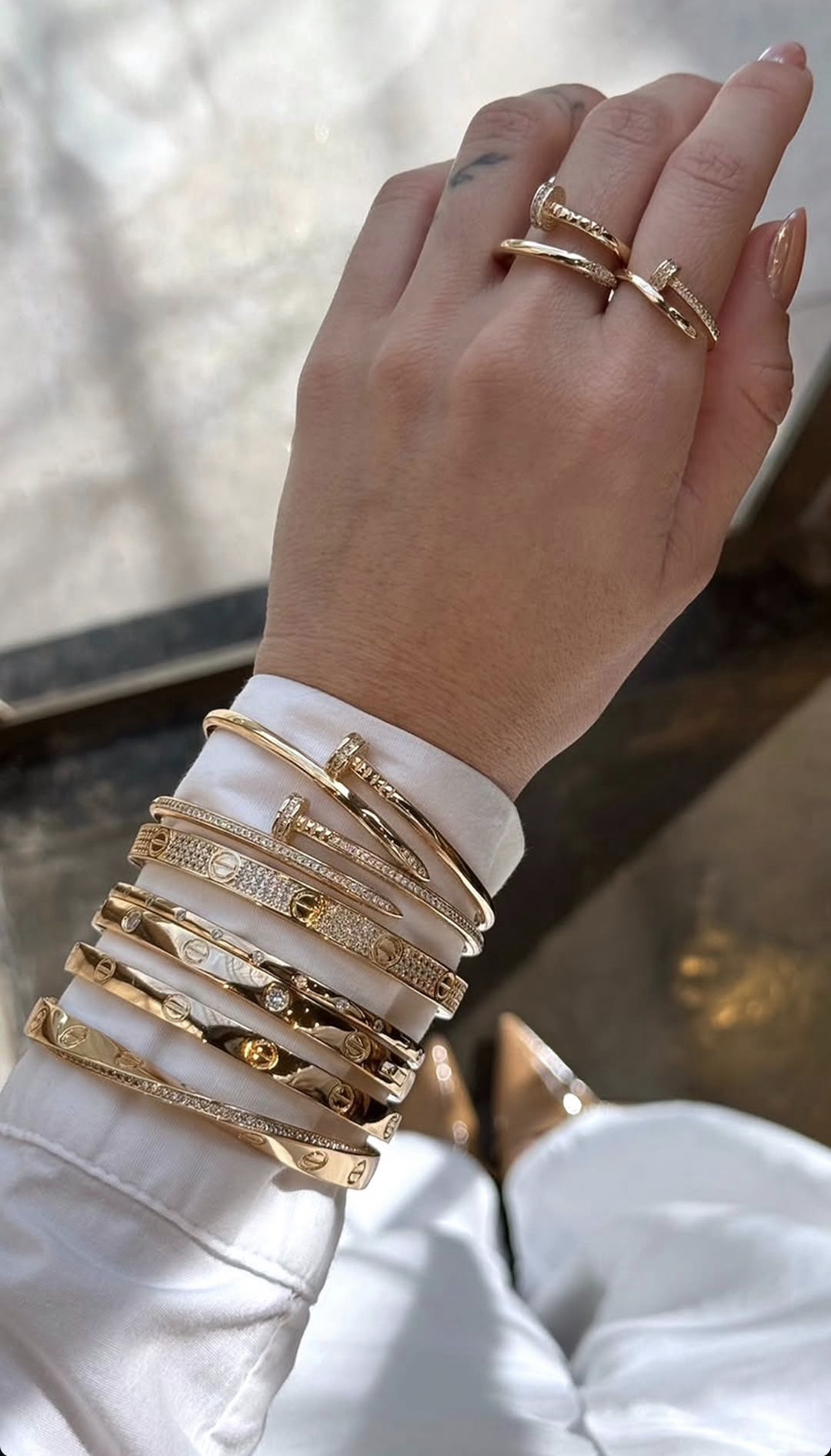 Pulseiras e anéis dourados em composição elegante